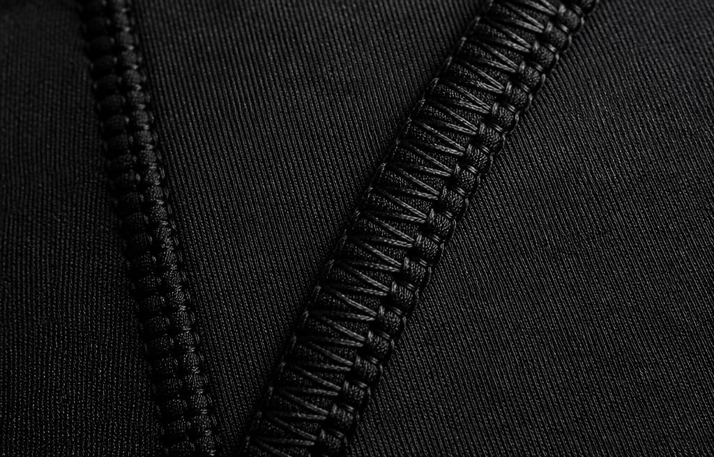 Macro detail of technical compression stitching on black fabric